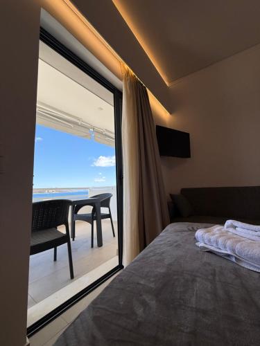 a bedroom with a bed and a view of the ocean at Thalassa Luxury Apartments Nea Styra in Nea Stira