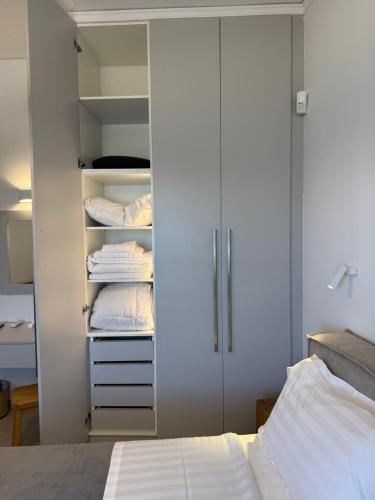 a bedroom with a bed and a white closet at Thalassa Luxury Apartments Nea Styra in Nea Stira