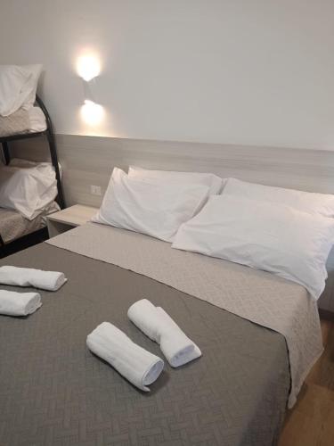 a bed with two white pillows and towels on it at bed end breakfast scalea da romina in Scalea
