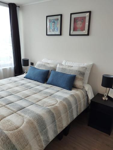 een slaapkamer met een groot bed met blauwe kussens bij Open Suite 3 in Temuco