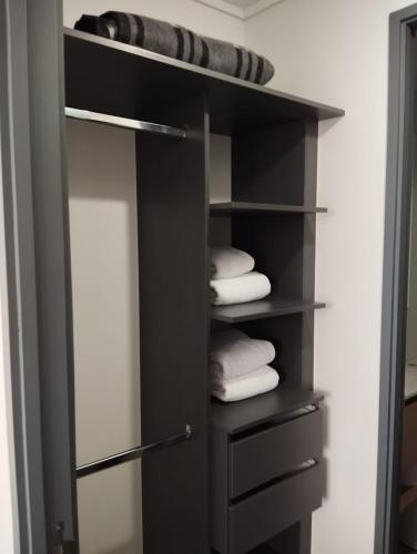 um armário preto com algumas toalhas em uma prateleira em Open Suite 3 em Temuco