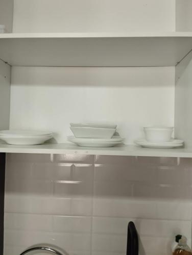 uma prateleira com pratos e tigelas na cozinha em Open Suite 3 em Temuco