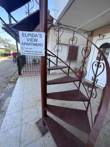 a spiral staircase with a sign on the side of a building at Elpida view apartment in Kyllini
