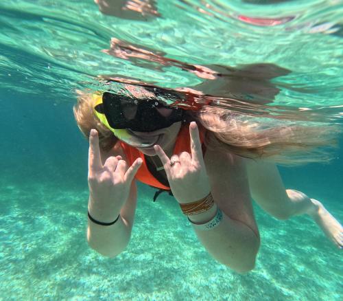 a woman in the water with a ball in her mouth at Nado con tortugas marinas en akumal in Akumal