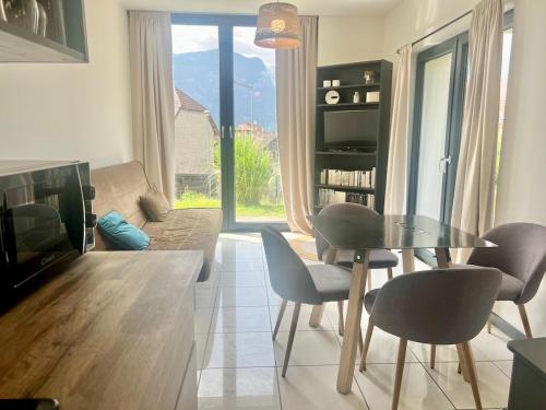 un salon avec une table, des chaises et un canapé dans l'établissement T3 Terrasse, parking, montagne, à Thyez