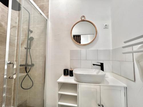 une salle de bain blanche avec un lavabo et une douche dans l'établissement T3 Terrasse, parking, montagne, à Thyez