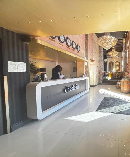 a woman sitting at a counter in a restaurant at ONOMO Hotel Waterfront in Cape Town