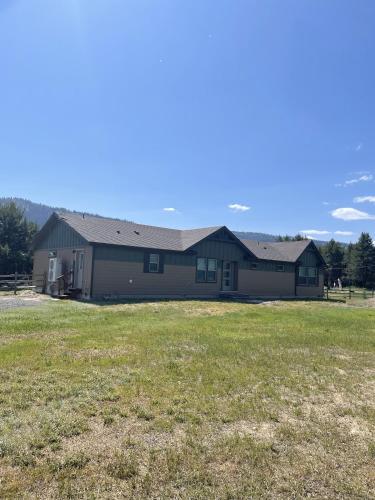 a large house with a field in front of it at New! Grand Manor - Close to Tamarack and Lake Cascade - Pet friendly - fenced yard - trailer parking in Donnelly