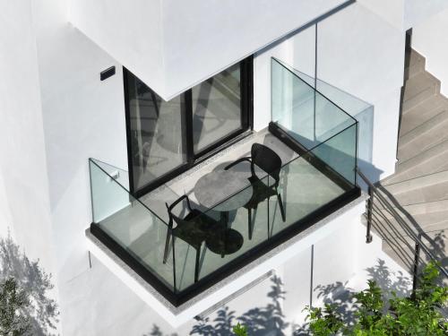 two chairs on the glass balcony of a house at Hotel AURA in Sarandë