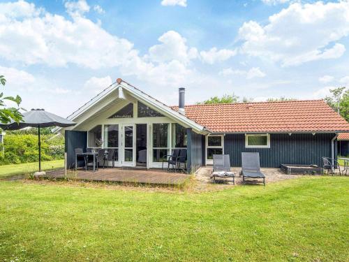 a small blue house with a deck and chairs at 6 person holiday home in Hemmet-By Traum in Hemmet