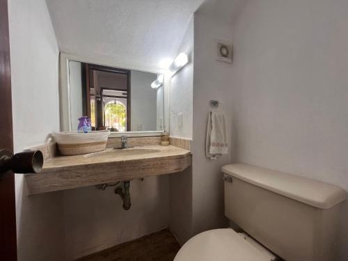 Un baño con lavabo, inodoro y espejo. en The Villa of Dreams, en Cancún