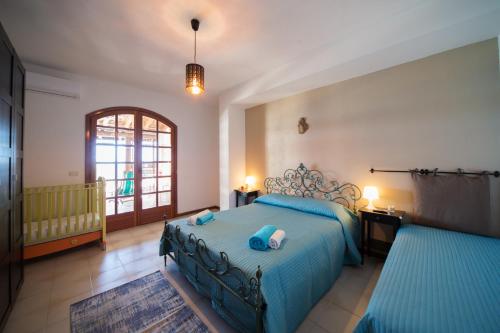 ein Schlafzimmer mit einem blauen Bett und einem Fenster in der Unterkunft Casa di Mare Barabba in Santa Teresa di Riva