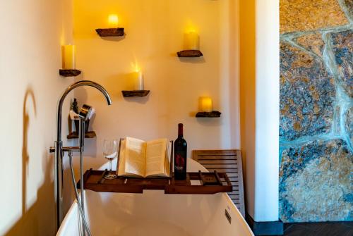 a bathroom with a bath tub with a bottle of wine and a book at En'kanto Valle de Guadalupe in San Marcos