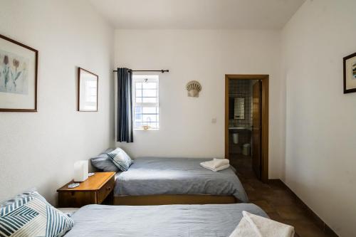 a small room with two beds and a window at Casa das Conchas in Carvoeiro