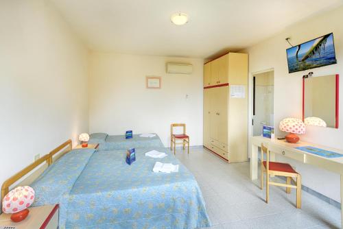 a bedroom with a blue bed and a desk at Hotel Casa Rosa in Portoferraio