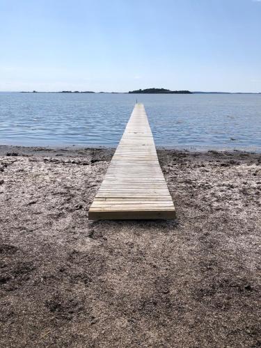 a wooden pier on the shore of a body of water at Birkelygaard B&B in Millinge