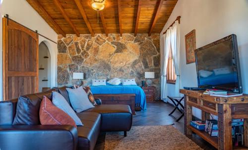 a living room with a couch and a bed at En'kanto Valle de Guadalupe in San Marcos