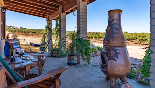 a large vase sitting on a patio next to a table at En'kanto Valle de Guadalupe in San Marcos