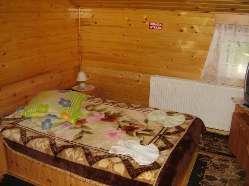 a bedroom with a bed in a wooden room at Pension Bran Ioana& SPA in Bran
