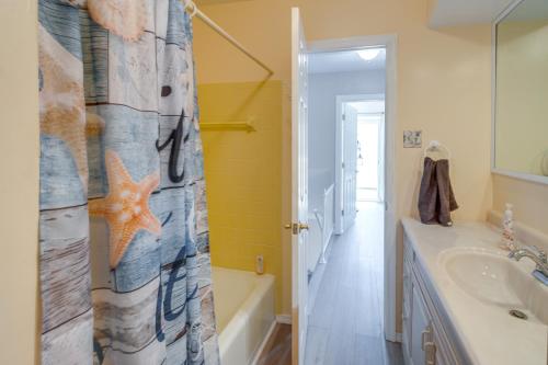 a bathroom with a shower curtain with a tub and a sink at Walk to Brigantine Beach Condo with Furnished Patio in Brigantine