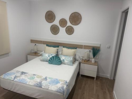a bedroom with a bed with two tables and two mirrors at Apartamento Bajo de Guía bajo A in Sanlúcar de Barrameda