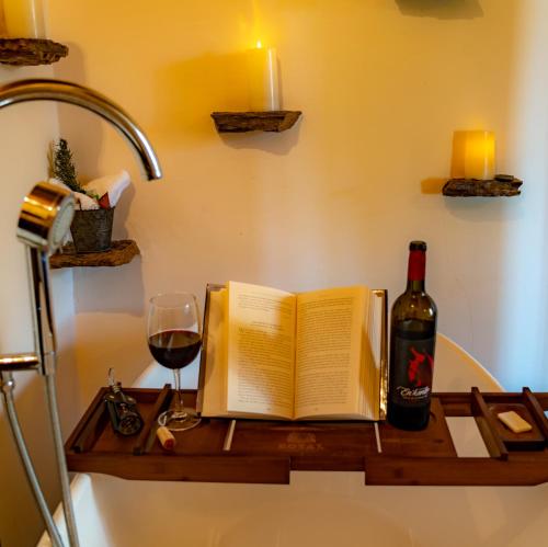 a book and a glass of wine on a table at En'kanto Valle de Guadalupe in San Marcos