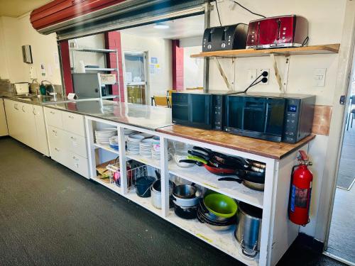 a kitchen with a counter with dishes on shelves at The Crossing Lodge & Backpackers in National Park