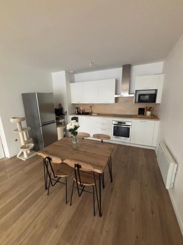 - une cuisine avec une table et des chaises en bois dans la chambre dans l'établissement Studio lumineux 45m2, à Annemasse