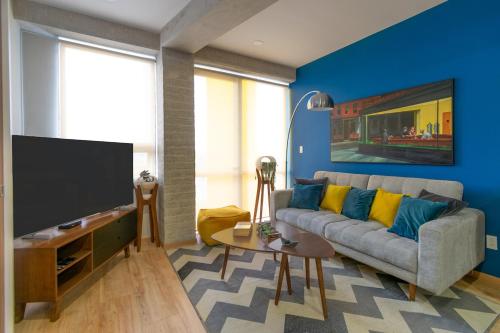 a living room with a couch and a flat screen tv at San Ángel modern luxury in Mexico City