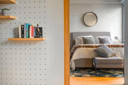 a bedroom with a bed with a mirror and a chair at San Ángel modern luxury in Mexico City