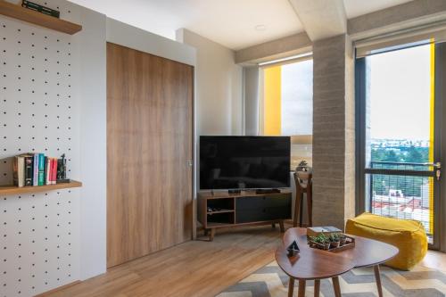 a living room with a large television and a table at San Ángel modern luxury in Mexico City
