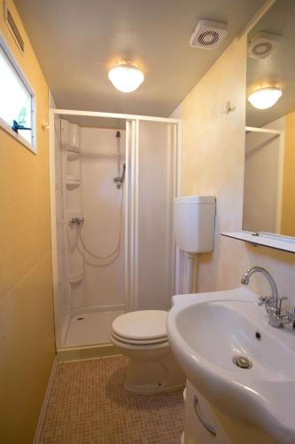 a bathroom with a shower and a toilet and a sink at Mobilehome in Aquileia 50114 in Aquiléia