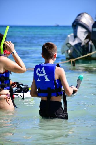 a young boy wearing a life vest in the water at Nado con tortugas marinas en akumal in Akumal