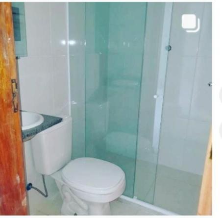a bathroom with a toilet and a glass shower at C&R hostel residência in Salvador
