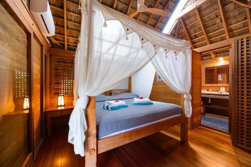 a bedroom with a canopy bed in a room at Fare Makana in Maharepa