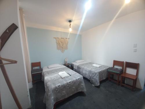 a room with two beds and a chandelier at Hospedaje Velilu in Ica