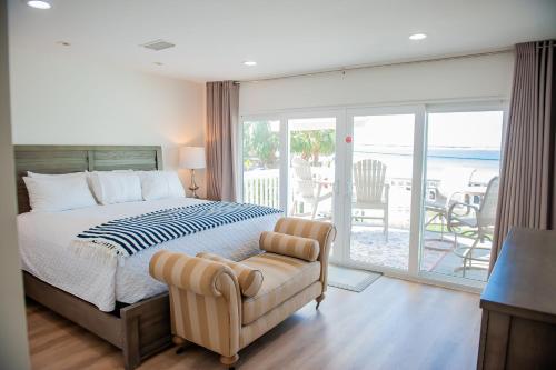 ein Schlafzimmer mit einem Bett und einem Stuhl sowie einem Balkon in der Unterkunft Family Tides in Destin