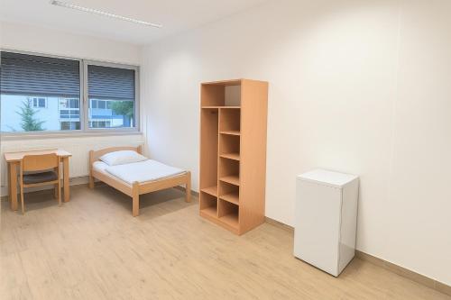 a room with a desk and a chair and a table at NonStop Home in Munich