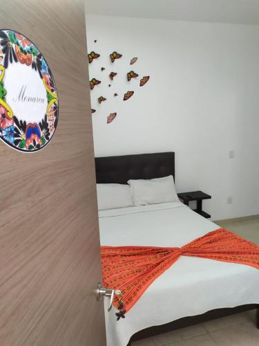 a bedroom with a bed with butterflies on the wall at Manuel Muñiz in Morelia