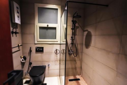 a bathroom with a shower with a toilet and a window at Rivana Residence New Cairo - Pool Access in Cairo