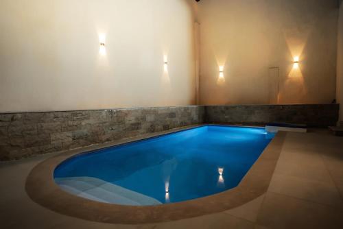 a swimming pool with blue water in a room with lights at Rivana Residence New Cairo - Pool Access in Cairo