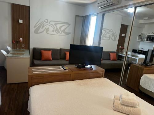 a living room with a couch and a television at Águas Claras in Brasilia