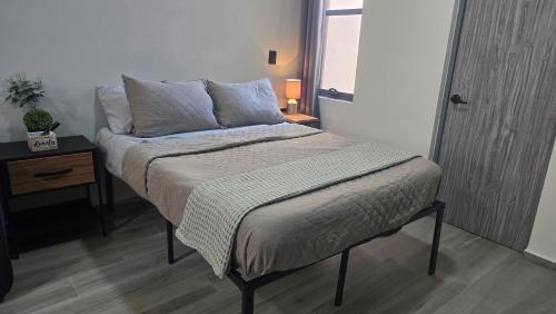 a bed in a room with a nightstand and a bed sidx sidx at Depto Tec by tuhost in Monterrey