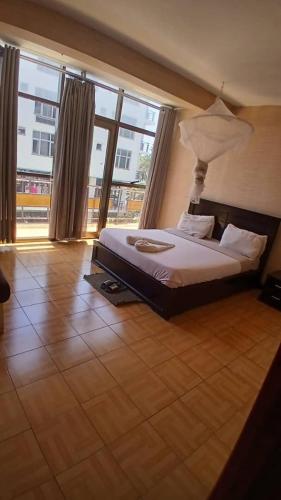 a bedroom with a bed and a large window at Dagmaros Guest House in Bahir Dar