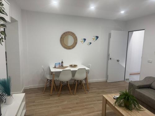 a living room with a white table and chairs at Apartamento Bajo de Guía Primero A in Sanlúcar de Barrameda