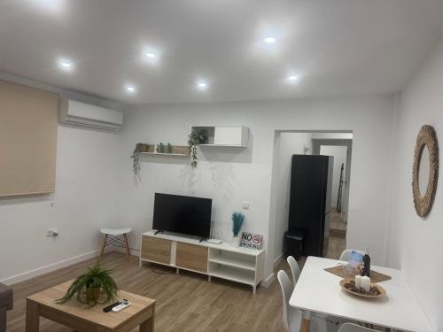 a living room with a flat screen tv and a table at Apartamento Bajo de Guía Primero A in Sanlúcar de Barrameda