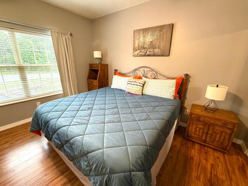 a bedroom with a bed with a blue comforter and a window at Lakefront and Lake View Condo on Indian Point in Branson