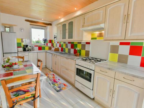 - une cuisine avec du carrelage coloré sur le mur dans l'établissement Maison des Yourtes, à Loubejac