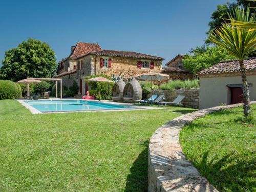 une maison avec une piscine en face d'une cour dans l'établissement Petit gite Saint Martin le Redon, à Soturac
