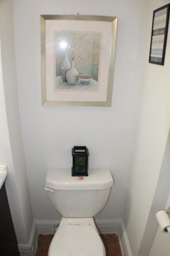 a bathroom with a toilet with a picture on the wall at Southend Gem in Hartford